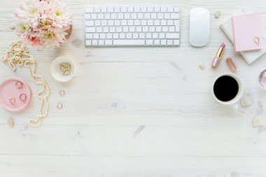 Üst kat ofis masası. Çalışma alanı, bilgisayar, kasımpatı, pano. Beyaz ahşap arka planda izole kadın aksesuarları. Düz yatıyordu