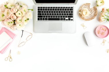 Tarz sahibi kadınların ofis masası. Laptop, bilgisayar, buket ranunculus ve güllerle çalışma alanı, beyaz arka planda pano. Düz yatıyordu. Üst görünüm.