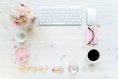 Üst kat ofis masası. Çalışma alanı, bilgisayar, kasımpatı, pano. Beyaz ahşap arka planda izole kadın aksesuarları. Düz yatıyordu