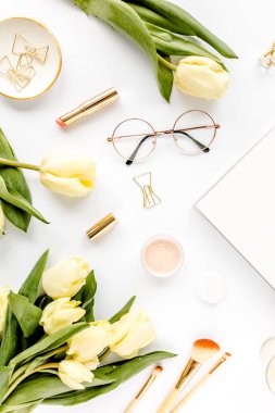 Sarı lale çiçekli kadın çalışma alanı, kadınların moda altın aksesuarları, günlük, beyaz arka planda gözlük. Düz yatıyordu. Üst görünüm arkaplanı.