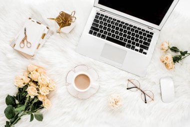 Dizüstü bilgisayarı, gülleri, altın aksesuarları, günlüğü, bilgisayarı, beyaz arka planda gözlüğü olan kadın çalışma alanı. Düz uzanmış kadınların ofis masası. Üst görünüm