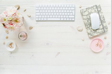 Üst kat ofis masası. Çalışma alanı, bilgisayar, kasımpatı, pano. Beyaz ahşap arka planda izole kadın aksesuarları. Düz yatıyordu