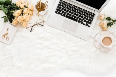 Dizüstü bilgisayarı, gülleri, altın aksesuarları, günlüğü, bilgisayarı, beyaz arka planda gözlüğü olan kadın çalışma alanı. Düz uzanmış kadınların ofis masası. Üst görünüm