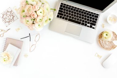 Tarz sahibi kadınların ofis masası. Laptop, bilgisayar, buket ranunculus ve güllerle çalışma alanı, beyaz arka planda pano. Düz yatıyordu. Üst görünüm.