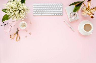 Ofis masasında bilgisayar, leylak ve dosya var. Dergiler. Üst Manzara Düz Yatıyordu. Merkez ofis çalışma alanı. Pembe arka planda kadın moda aksesuarları