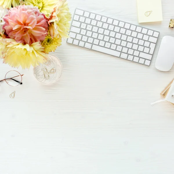 Biurko dla kobiet. Kobieca przestrzeń robocza z komputerem, różowe i żółte róże kwiaty, akcesoria, pamiętnik, okulary na białym tle. Widok z góry — Zdjęcie stockowe