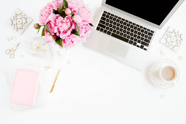 Escritorio de oficina de mujeres laicas planas. Espacio de trabajo femenino con portátil, ramo de peonías rosadas, accesorios sobre fondo blanco. Vista superior fondo femenino. —  Fotos de Stock