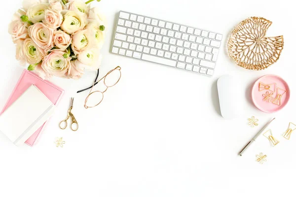 Scrivania stilizzata per ufficio femminile. Spazio di lavoro con computer, bouquet ranuncolo e rose, appunti su sfondo bianco. Piatto. Vista dall'alto. — Foto Stock