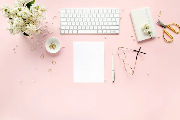 Workspace with computer, bouquet lilac, clipboard. Womens fashion accessories isolated on pink background. Flat lay. Top view office desk. — Stock Photo, Image