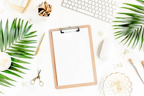 Flat lay mesa de escritório em casa. Espaço de trabalho feminino com computador, área de transferência, folhas de palma tropicais, acessórios sobre fundo branco. Vista superior. — Fotografia de Stock