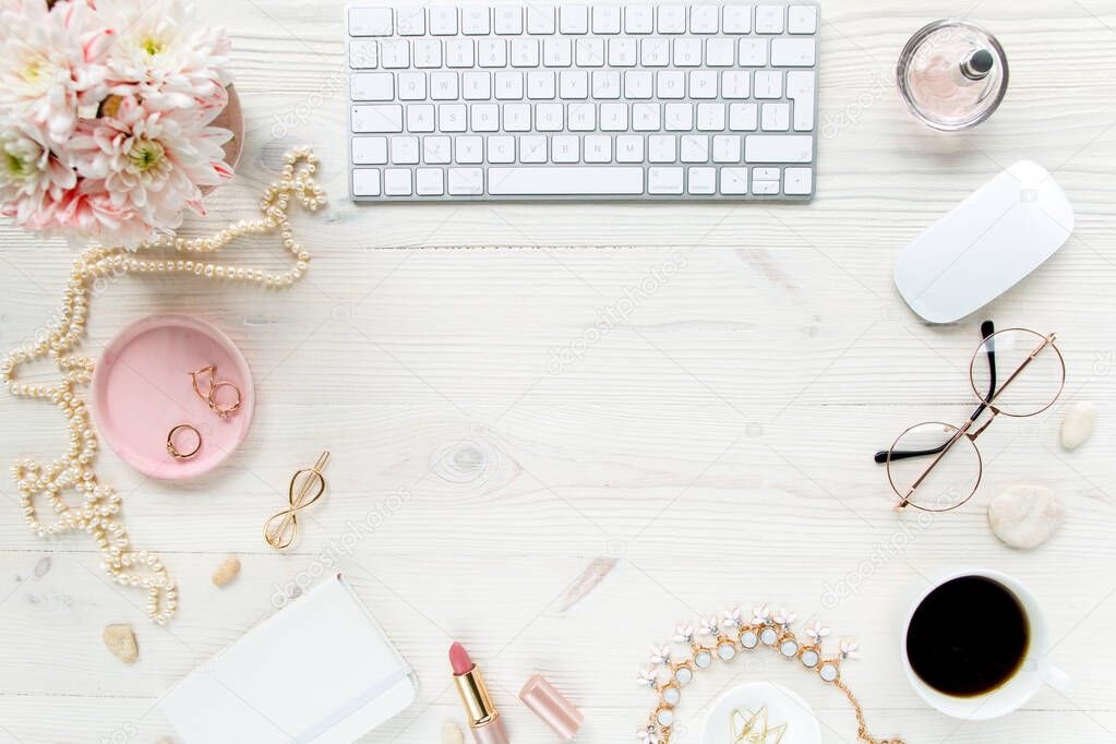 Top view office desk. Workspace with, computer, chrysanthemum, clipboard. Womens fashion accessories isolated on white wooden background. Flat lay