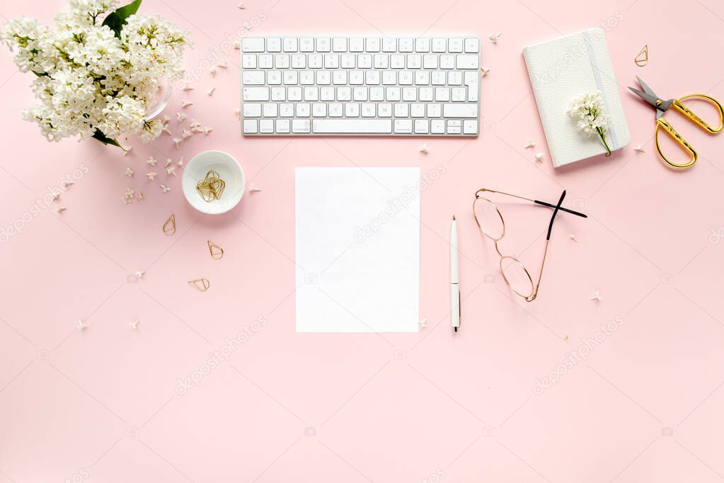 Workspace with computer, bouquet lilac, clipboard. Womens fashion accessories isolated on pink background. Flat lay. Top view office desk. 