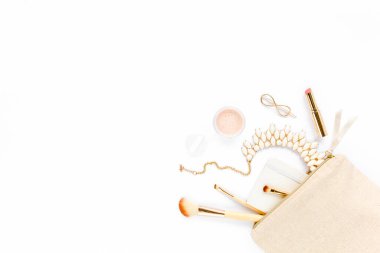 Bej makyaj çantası, makyaj fırçası, kozmetik, beyaz arka planda altın aksesuarlar. Düz kompozisyon. Dergiler, sosyal medya. Üst Manzara. Düz yatıyordu. 