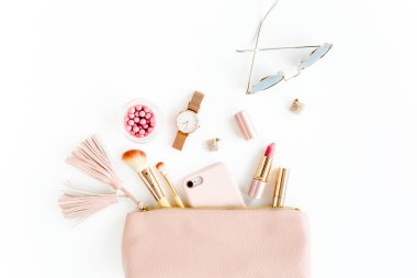 Beyaz arka planda izole edilmiş pembe kozmetik çantalı, kozmetik makyaj ürünleri içeren düz bir kompozisyon. Düz yatış, üst görünüm.