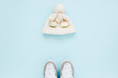 Beyaz kadınlar botları ve şapkaları giyer, mavi arka planda gözlük takarlar. Düz yatış, üst görünüm moda kadınsı arka plan. Güzellik günlüğü konsepti.