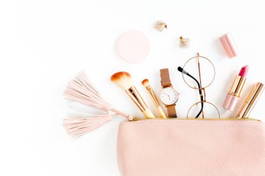 Beyaz arka planda izole edilmiş pembe kozmetik çantalı, kozmetik makyaj ürünleri içeren düz bir kompozisyon. Düz yatış, üst görünüm.