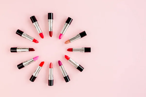 Set de lápices labiales de color sobre fondo rosa. Cosméticos decorativos profesionales, pomada de productos. Composición plana belleza, moda. plano, vista superior — Foto de Stock