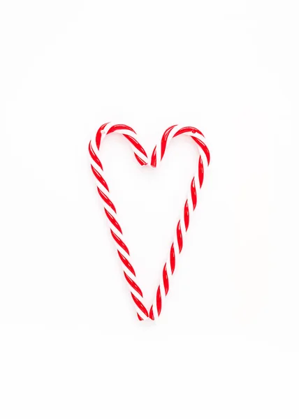 Cuore simbolo fatto di caramelle di Natale su sfondo bianco. Posa piatta, vista dall'alto. — Foto Stock