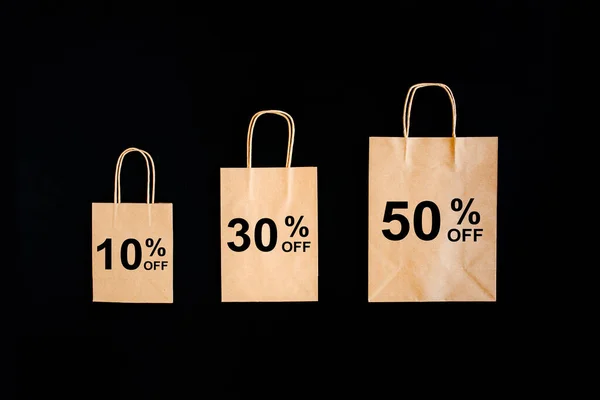 Black Friday concept de réduction des ventes. Sacs en papier artisanal avec mot Vente sur fond noir. — Photo