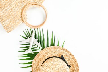 Eko rattan çanta, model uçak, uçak, hasır şapka ve tropikal palmiye yaprağı. Beyaz arka planda gezgin aksesuarları konsepti. Yaz dönemi. Düz yatıyordu