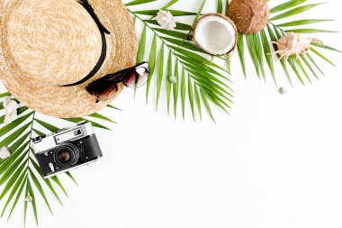 Gezgin aksesuarları, tropikal palmiye yaprağı dalları, beyaz arka planda hasır şapka ve metin için boş alan. Seyahat tatili kavramı. 