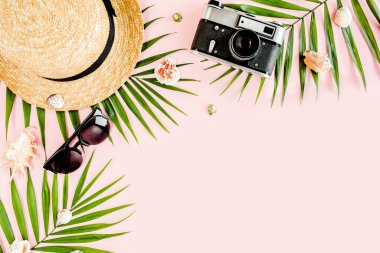 Kadın plaj aksesuarları: bikini, rattan çanta, hasır şapka, sarı arka planda tropik palmiye yaprakları. Yaz arkaplanı. 