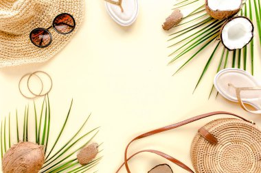 Kadın plaj aksesuarları: bikini, rattan çanta, hasır şapka, sarı arka planda tropik palmiye yaprakları. Yaz arkaplanı. 