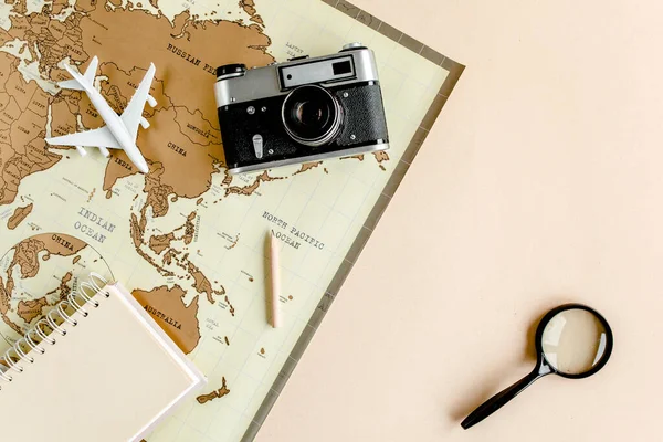Planificación de vacaciones, plan de viaje, vacaciones de viaje utilizando el mapa del mundo junto con otros accesorios de viaje. Vista superior, plano. — Foto de Stock