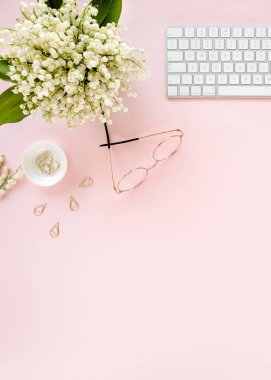 Ofis masasında bilgisayar, leylak ve dosya var. Dergiler. Üst Manzara Düz Yatıyordu. Merkez ofis çalışma alanı. Pembe arka planda kadın moda aksesuarları