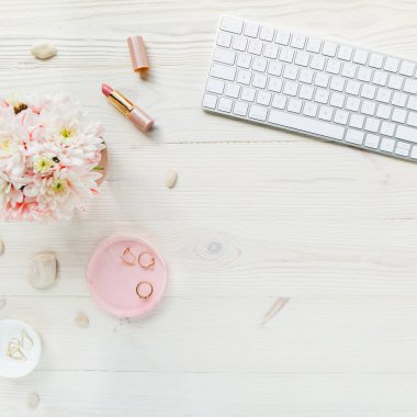 Üst kat ofis masası. Çalışma alanı, bilgisayar, kasımpatı, pano. Beyaz ahşap arka planda izole kadın aksesuarları. Düz yatıyordu