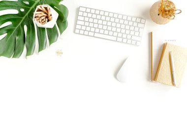 Bilgisayarlı kadın ofis masası çalışma alanı, tropikal palmiye yaprakları, beyaz arka planda aksesuarlar. Üst görünüm kadınsı arkaplan. 