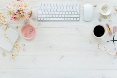 Üst kat ofis masası. Çalışma alanı, bilgisayar, kasımpatı, pano. Beyaz ahşap arka planda izole kadın aksesuarları. Düz yatıyordu