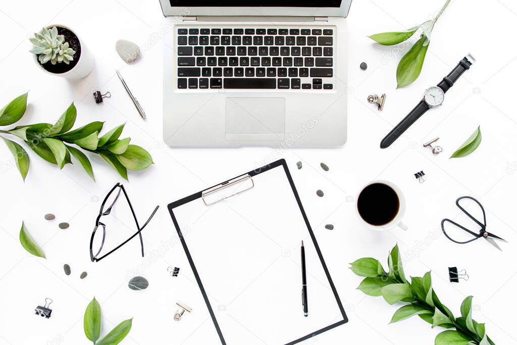 Office desk. Workspace frame with paper blank, green leaves. Laptop, glasses on white background. Magazines, websites, media. Flat lay, top view