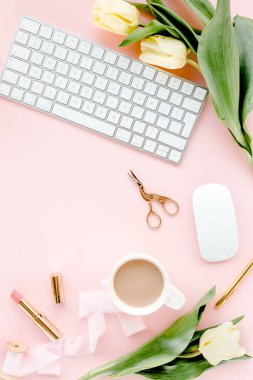 Bilgisayarlı kadın çalışma alanı, lale çiçekleri buketi, altın aksesuarlar, pembe arka planda günlük. Düz uzanmış kadınların ofis masası. Üst görünüm