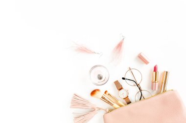 Beyaz arka planda izole edilmiş pembe kozmetik çantalı, kozmetik makyaj ürünleri içeren düz bir kompozisyon. Düz yatış, üst görünüm.