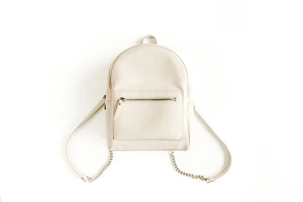 Mochila bege das mulheres com acessórios de moda no fundo branco vista superior. Aparência de estilo feminino leigo plano. Vista superior. — Fotografia de Stock