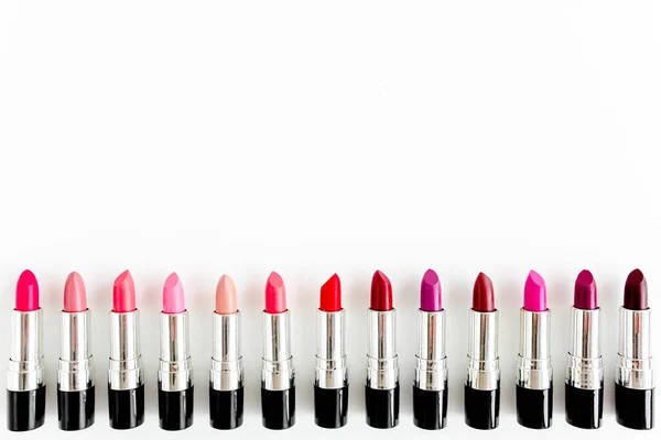 Set de lápices labiales de color sobre fondo blanco. Cosméticos decorativos profesionales, pomada de producto para publicidad. belleza, moda. plano, vista superior — Foto de Stock