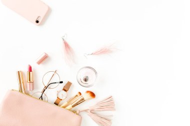 Beyaz arka planda izole edilmiş pembe kozmetik çantalı, kozmetik makyaj ürünleri içeren düz bir kompozisyon. Düz yatış, üst görünüm.