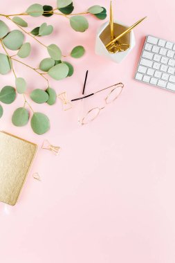 Bilgisayarlı ofis masası, yeşil yapraklı okaliptüs, dosya, altın aksesuarlar, günlük, gözlük. Dergiler, sosyal medya. Üst Manzara. Düz yatıyordu. 