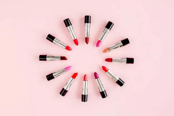 Set de lápices labiales de color sobre fondo rosa. Cosméticos decorativos profesionales, pomada de productos. Composición plana belleza, moda. plano, vista superior — Foto de Stock