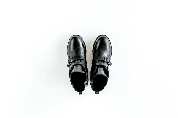 Zwarte vrouwelijke laarzen op witte achtergrond. Vlakke lay, bovenaanzicht minimale achtergrond. Modeblog of tijdschrift concept. — Stockfoto
