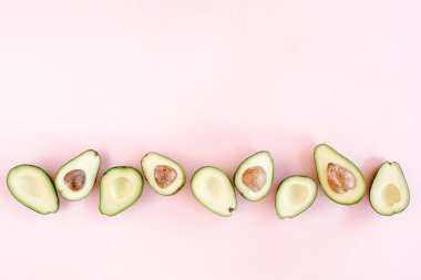 Pembe arka planda avokado. Avokadolu tropik soyut bir arka plan. Yemek konsepti. düz yatış, üst görünüm
