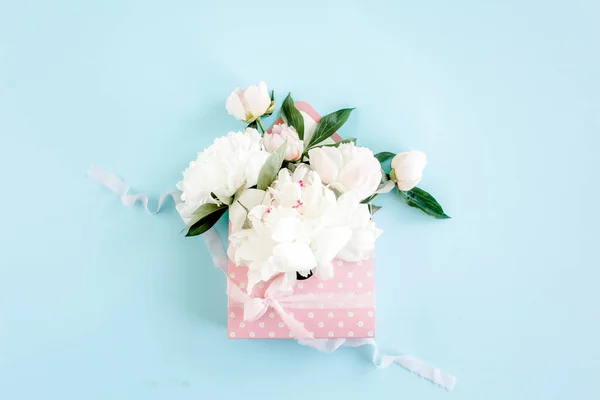 Ramo blanco de peonías en un sobre para flores sobre fondo azul. Tarjeta de felicitación de concepto floral mínimo. Piso tendido, vista superior. —  Fotos de Stock