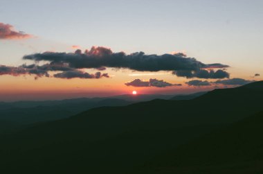 Günbatımı güneş dağların Hills bulutu ile