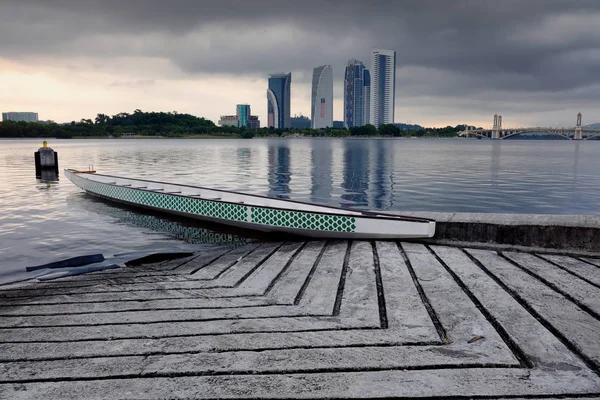 Boş dragon tekne göl tarafı gündoğumu arka plan üzerinde demir attı. Bulutlu gökyüzü ve yansıma yüzeyi