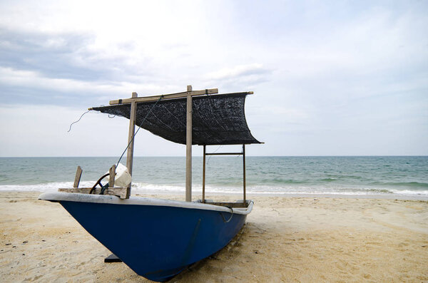 closed up fisherman boat stranded on the sandy beach and cloudy sky.color toning applied.color toning applied