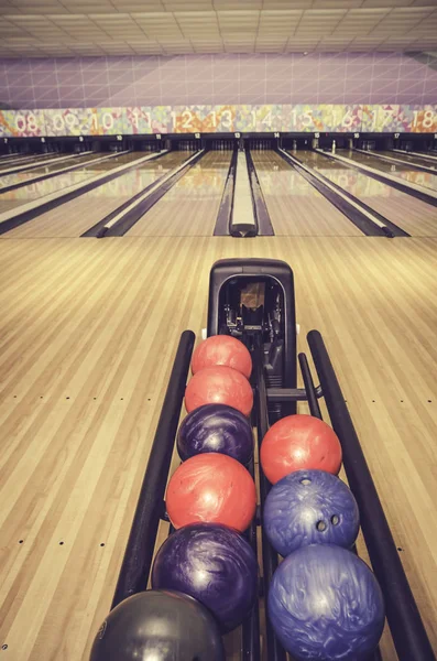 Retro görünüm kırmızı, mavi ve mor bowling topu. Lane ve bulanıklık arka plan Bovling