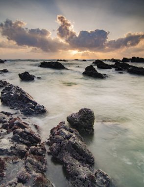 Güneş ışığı, gün batımı gündoğumu Pandak Beach, Terengganu, Malezya benzersiz kaya oluşumu ve bulutlu gökyüzü ile toplayan çarpıcı. uzun pozlama ateş nedeniyle yumuşak odak