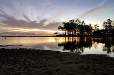 Siluet görüntüsü Terengganu, Malezya'da bulunan güzel Kuala Ibai deniz manzaralı. bulutlu gökyüzü ve düşük gelgit su sırasında kumlu plaj