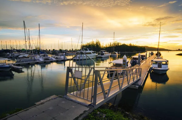 Yelkenli tekneler ve güzel bulutlu gün batımı arka plan ile yat kulübünde demirledi gökdelen